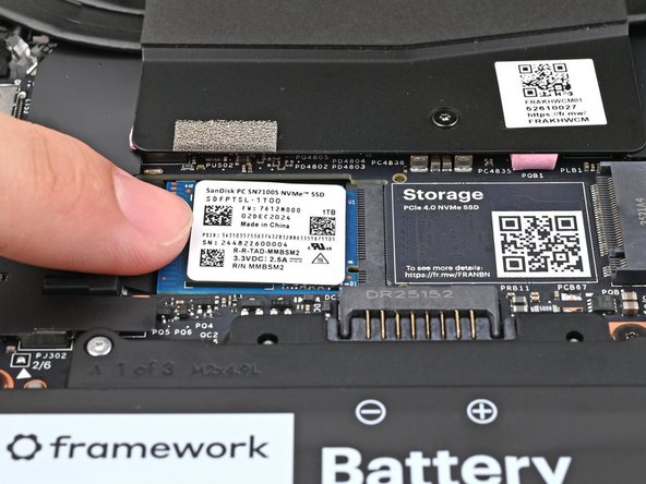 While keeping the SSD flat to the Mainboard, use your finger to slide the SSD into its socket until its golden contacts are completely covered.