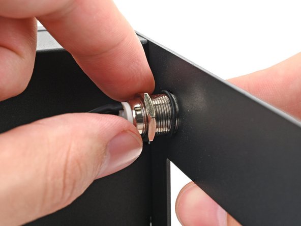 While holding the power button in place, tighten the nut over the threads of the power button until it's snug.