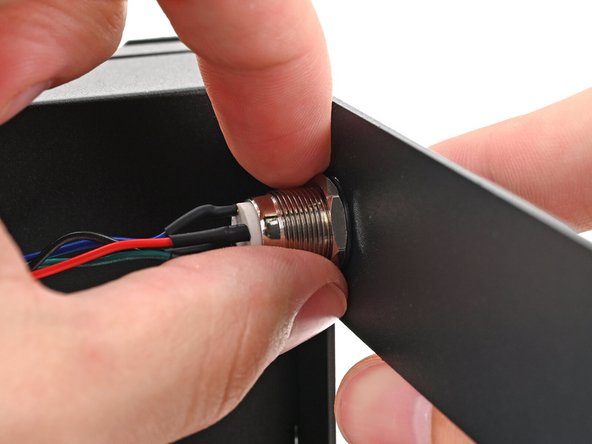 While holding the power button in place, tighten the nut over the threads of the power button until it's snug.