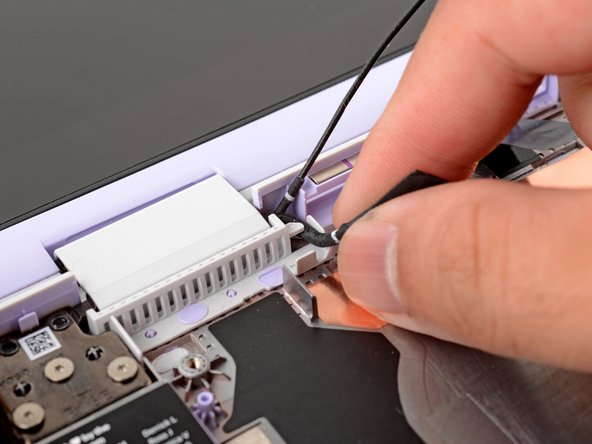 Use your fingers to gently lift the webcam cable out of its plastic channel.