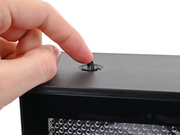 Use your finger to close the two D-rings on the top panel screws.