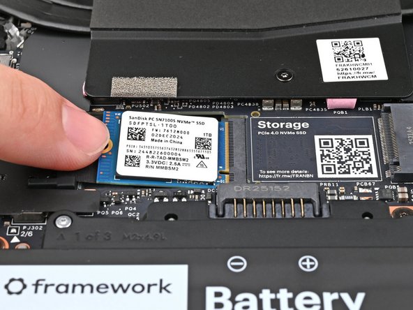 While keeping the SSD flat to the Mainboard, use your finger to slide the SSD into its socket until its golden contacts are completely covered.