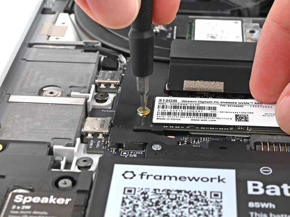 While holding the SSD flat to the Mainboard, use your Framework Screwdriver to install the 2 mm‑long T5 Torx screw securing the primary SSD.