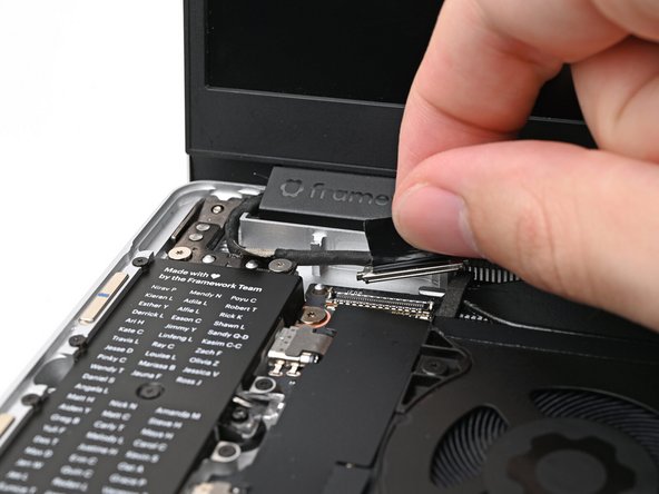 Place the Display eDP Cable into its slot on the Bottom Cover.