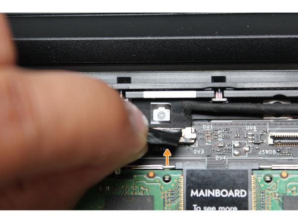 Using your fingers, carefully disconnect the Webcam cable on the top, right hand side by using the black pull tab to pull it directly upward.