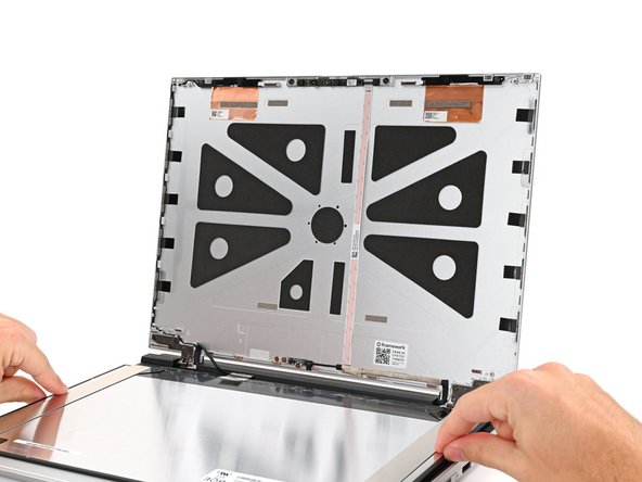 Align the display with its alignment pegs and place it on the Top Cover.