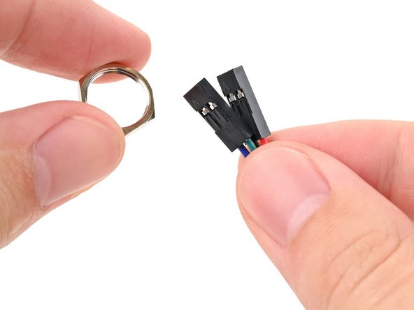 Thread the hexagonal nut over the power button cable and slide it down the length of the cable.