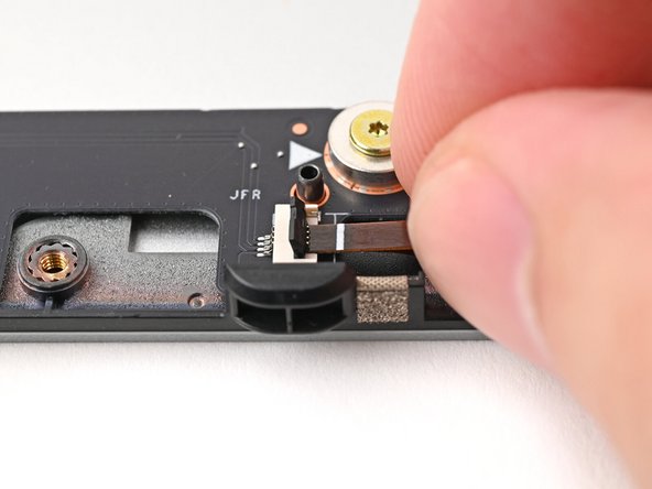 Use the flat end of your Framework Screwdriver, or a clean fingernail, to press down the locking tab on the right fan ZIF connector.