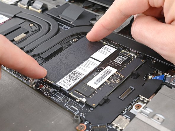 Push the two metal arms on each side of the RAM stick outward until they disengage and the stick pops up at a shallow angle.