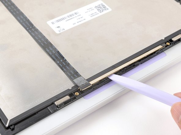 Use the flat end of your Framework Screwdriver to lift the webcam out of its recess.