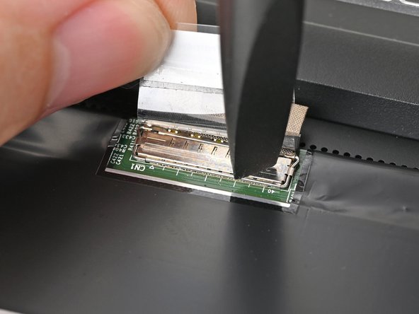 Push the metal locking tab down over the eDP cable connector until it snaps into place.