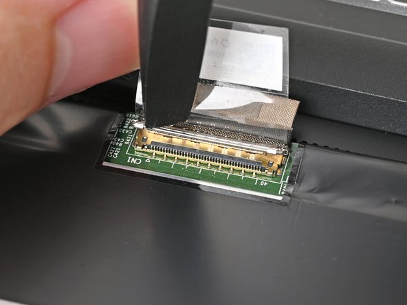 Push the metal locking tab down over the eDP cable connector until it snaps into place.