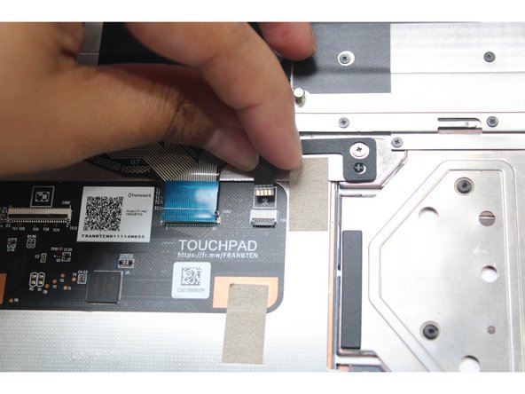 Connect the Keyboard Backlight Cable into the Touchpad.  Make sure the black latch is flipped up so that you can slide the cable into the connector.