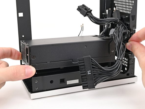 Lift the power supply out of its slot and let it rest on the left side of the Desktop.