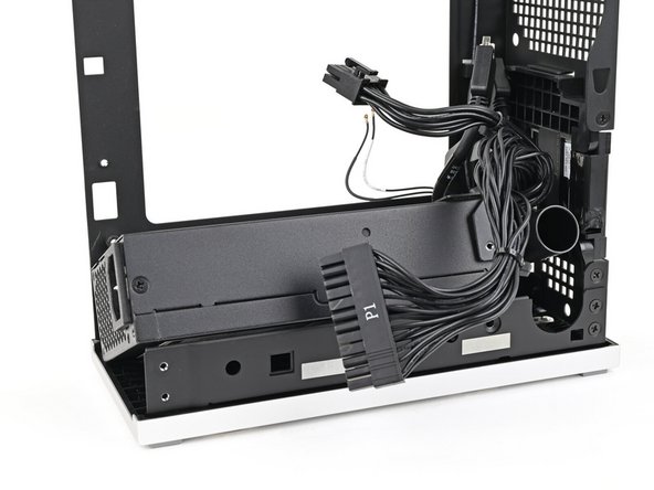 Lift the power supply out of its slot and let it rest on the left side of the Desktop.