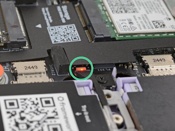 The red status LED near the right Expansion Card slots should blink continuously. If this LED isn't blinking, the laptop isn't receiving power correctly—try another USB-C port.