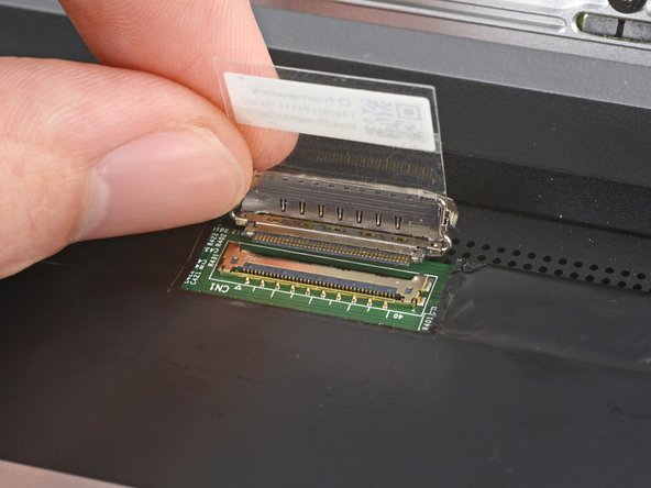 Grip the eDP cable where it meets the connector head.