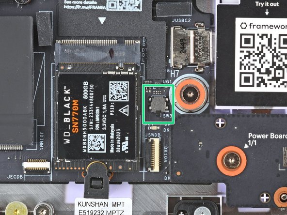 This switch is a sensor that detects if the Top Cover has been removed. It's a small silver block with a black toggle tab.