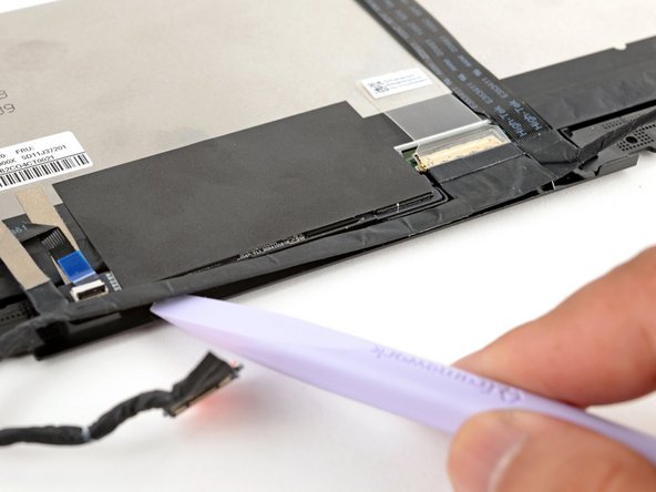 Slide the flat edge of your Framework Screwdriver under the length of the display cable to separate it from the display.