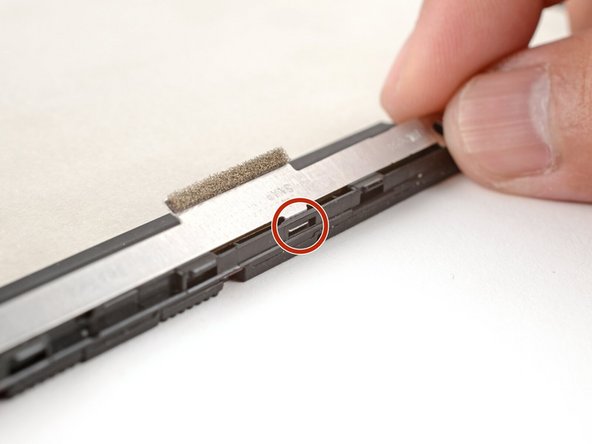 Make sure the tabs on the top edge of the webcam bracket sit in their slots on the top edge of the display.