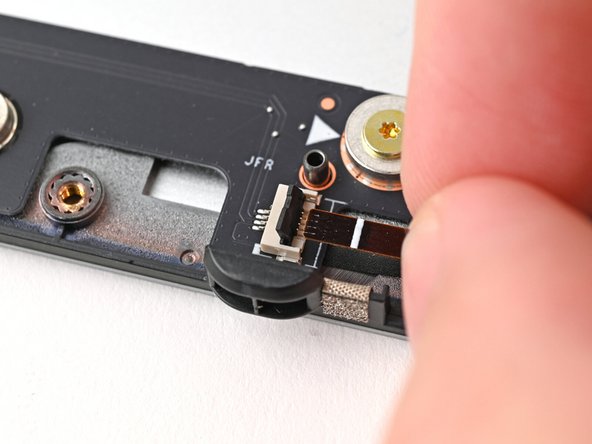 Use your fingers to grip the brown pull tab and slide the fan cable straight out of its socket.