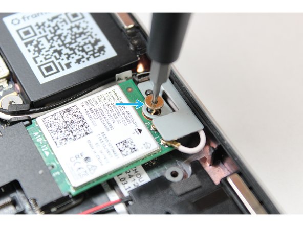Unscrew the fastener in the silver bracket holding down the WiFi module.