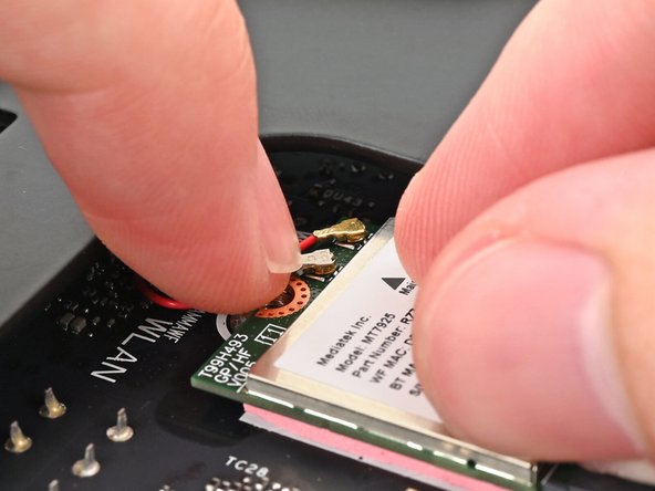 Hold the Wi-Fi module down with your fingers.