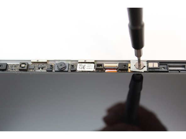Using the T5 Bit in the Framework Screwdriver, unscrew the two fasteners connecting the Webcam Module to the Top Cover.