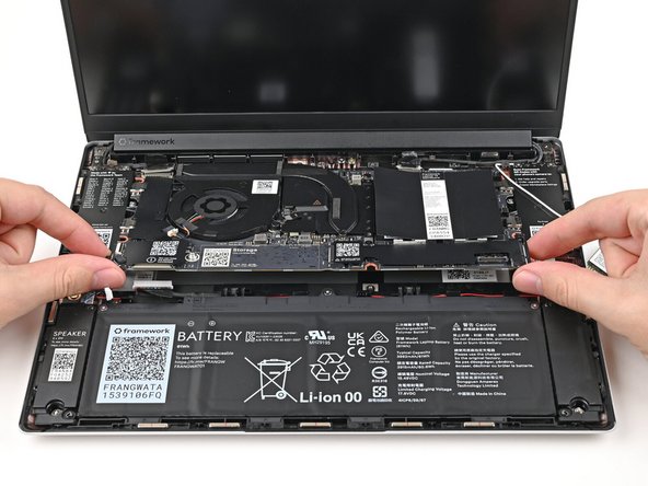 Grab the Mainboard by its edges and place it into the laptop and onto its alignment pegs.