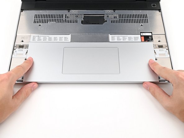 Use your fingers to slide the Touchpad Module toward the bottom edge of the laptop and disconnect it.