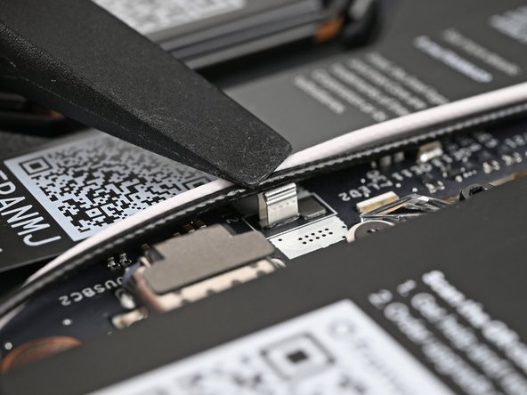 Use the flat end of your Framework Screwdriver to press the two Antenna Cables into their clips on the Mainboard.