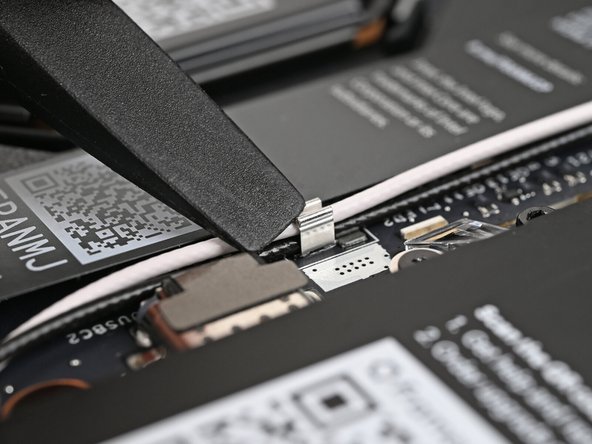 Use the flat end of your Framework Screwdriver to press the two Antenna Cables into their clips on the Mainboard.