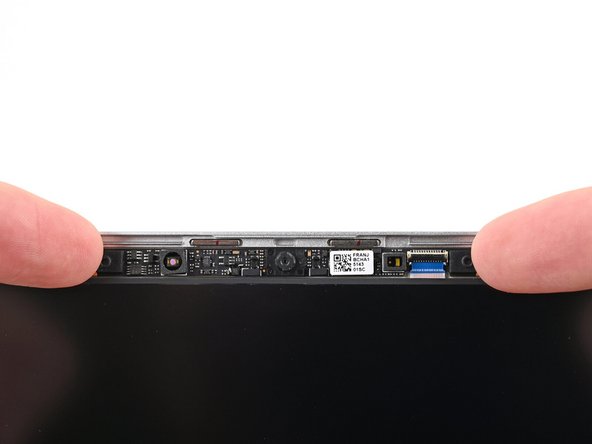 Grip the edges of the webcam and lift it straight up so its cable slides out of the ZIF connector.