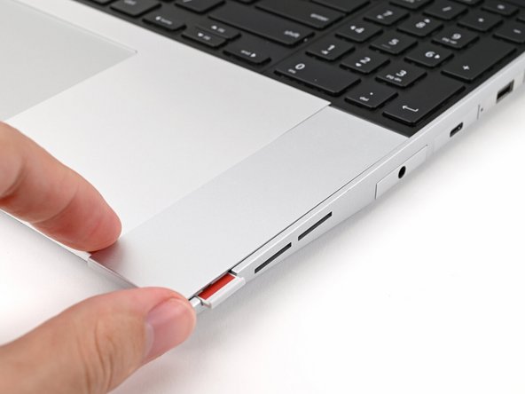 Slide the Touchpad Spacer towards the top of the laptop to secure it.
