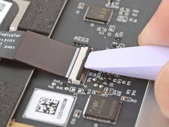 Use the flat end of your Framework Screwdriver or a fingernail to gently pry up the black locking tab on the touchpad cable ZIF connector, located on the back of the touchpad.