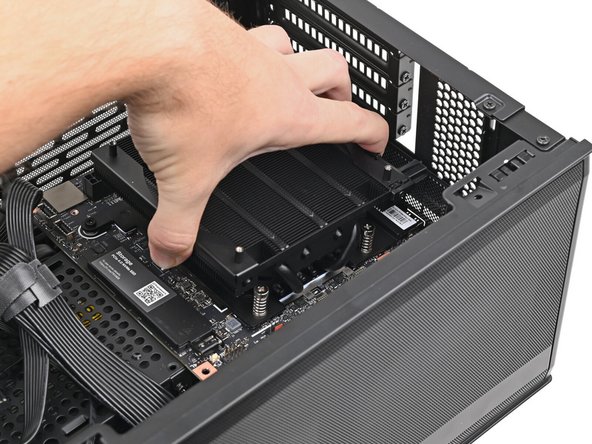Grip the Mainboard by the heatsink and place it into its cutout, making sure the ports aligns with its slot in the case.