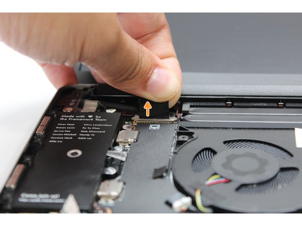 Using your fingers, carefully disconnect the Display cable on the top, left hand side by using the pull tab to pull it upward.