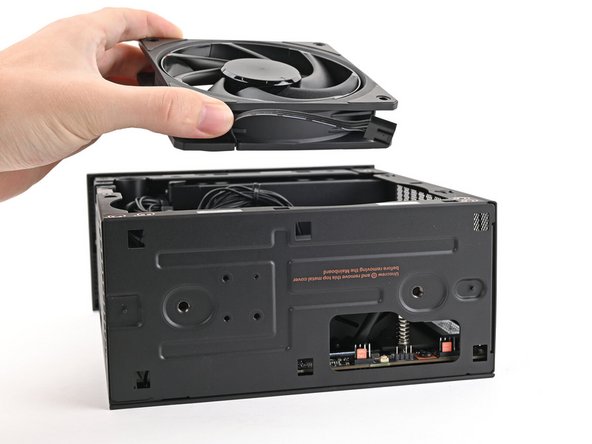 Orient the fan so its label is facing downward and the cable(s) is pointing towards the top of the computer.