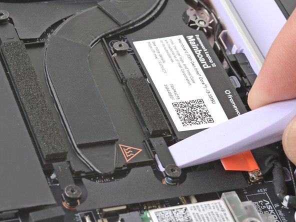 Slide the flat end of your Framework Screwdriver under the Heatsink arm labeled "2".