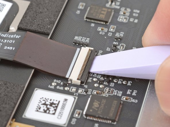 Use the flat end of your Framework Screwdriver or a fingernail to gently pry up the black locking tab on the touchpad cable ZIF connector, located on the back of the touchpad.