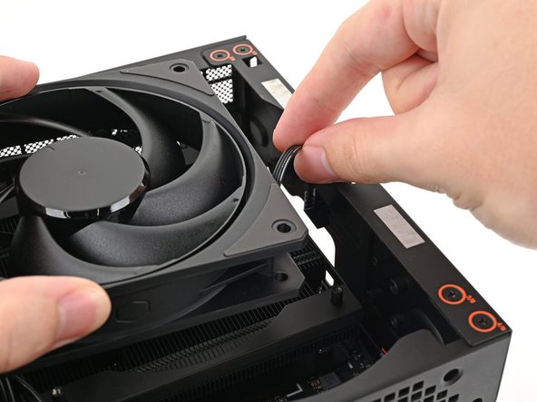 If the cables aren't routed properly, lift the fan up slightly and use your fingers to reposition the cables over the side of the heatsink.