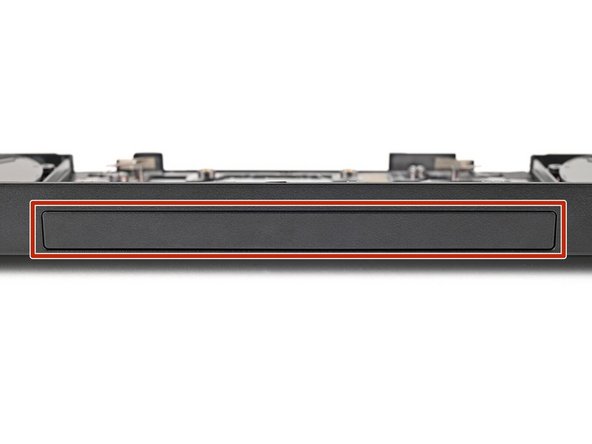 While holding the Expansion Bay Shell down, use the flat end of your Framework Screwdriver to push the plastic strip near the rubber spacer outwards.