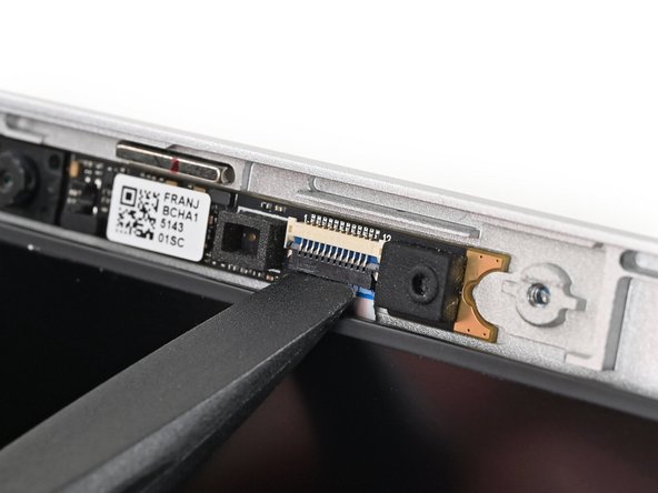 Use the flat end of a spudger, or a clean fingernail, to lift up the locking tab on the webcam ZIF connector.