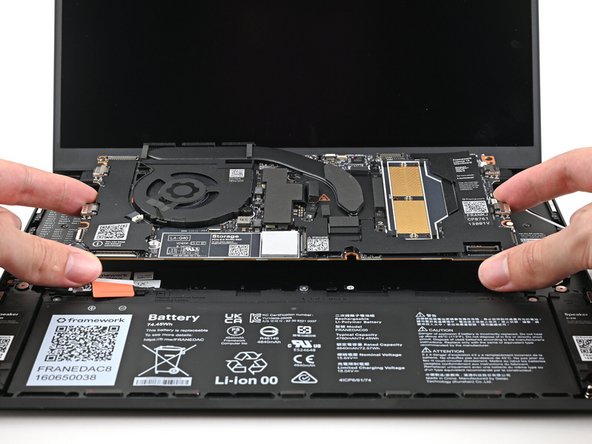 Grab the Mainboard by its edges and place it into the laptop and onto its alignment pegs.