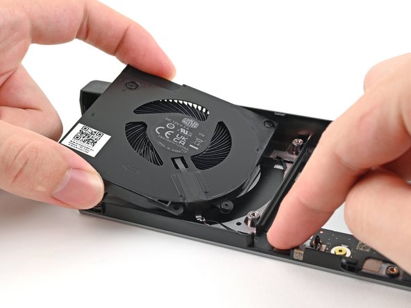 Use your other hand to pull the fan out of its housing, making sure to thread the cable through its slot.