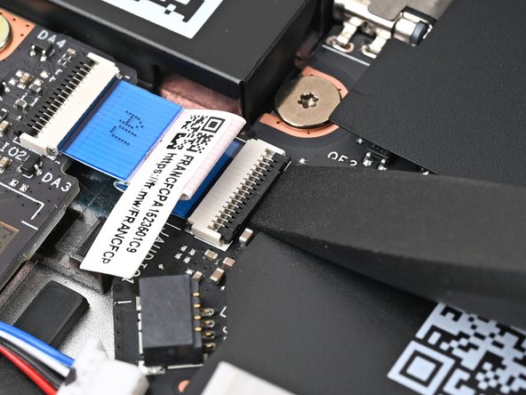 Use the flat end of your Framework Screwdriver, or a clean fingernail, to lift up the locking tab on the Audio Board ZIF connector on the Mainboard.