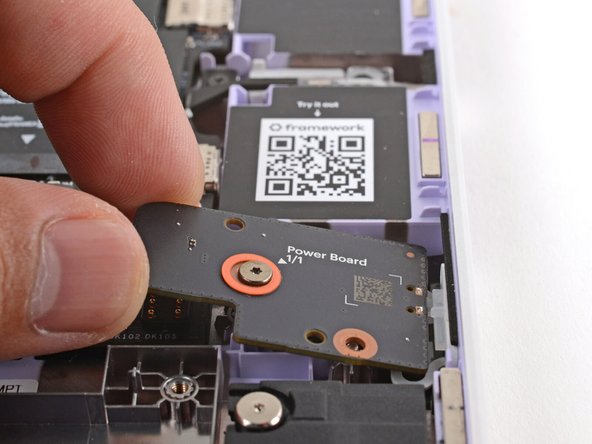 Use the two plastic pins on the laptop to align the Power Button Board.