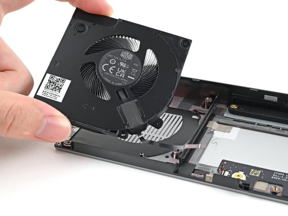 Use your other hand to pull the fan out of its housing, making sure to thread the cable through its slot.