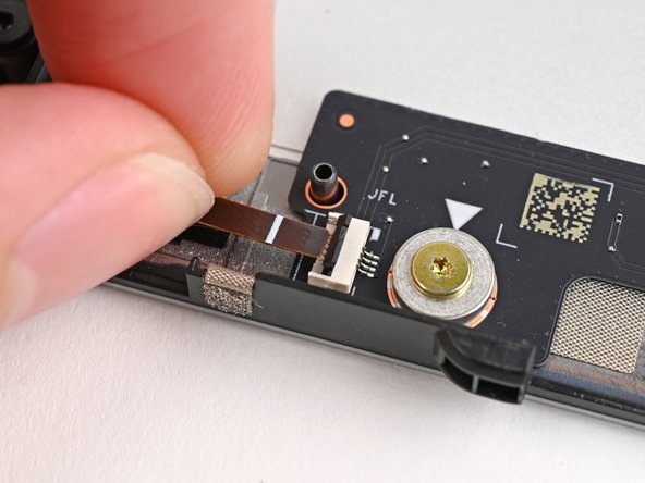 Use your fingers to grip the brown pull tab and slide the left fan cable straight out of its socket.