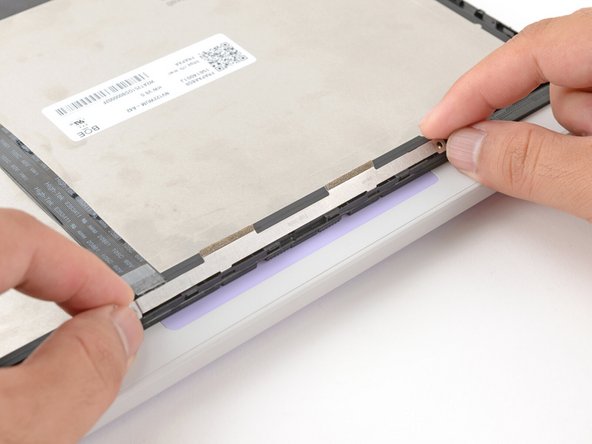 Make sure the tabs on the top edge of the webcam bracket sit in their slots on the top edge of the display.